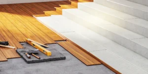 Installing a solid hardwood floor with planks and tools on the prepared subfloor.