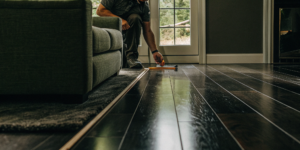 Measuring a floor to calculate the average labor cost to install laminate flooring.